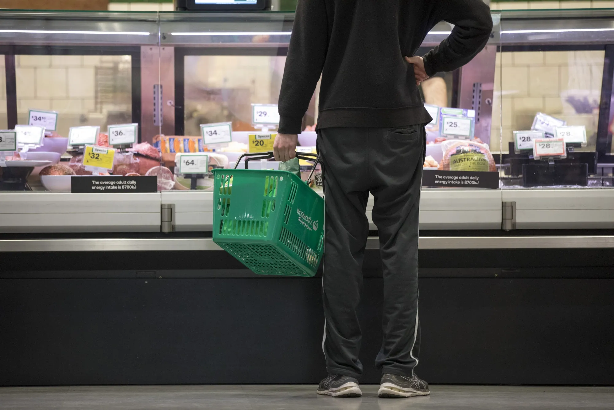 A customer waits at a meat counter at a Woolworths grocery store in Sydney, Australia.