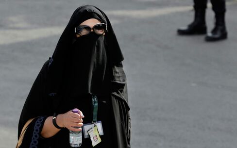 In this Wednesday, Nov. 11, 2015 photo, a journalist makes her way in Riyadh, Saudi Arabia. Outside the Saudi capital of Riyadh, in one of the country's most conservative provinces, Jowhara al-Wably is making history by running as a female candidate in upcoming elections. Saturday's vote for municipal council seats marks two milestones for Saudi women: It is the first time women are allowed to vote in a government election and the first time women can run as candidates.