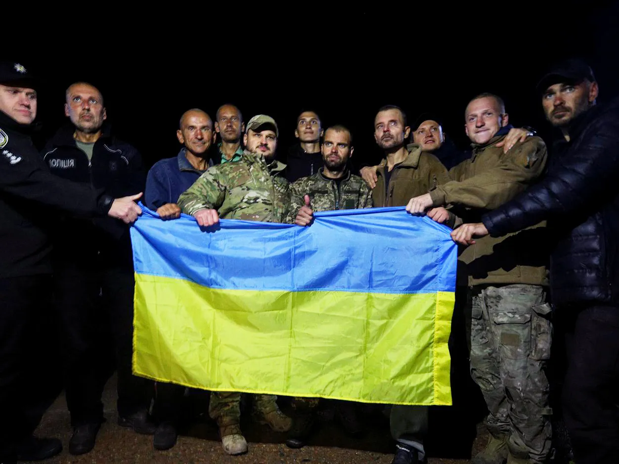 Returned servicemen hold a Ukrainian national flag following a prisoner swap, in Cherhnihiv region in the north of Ukraine.