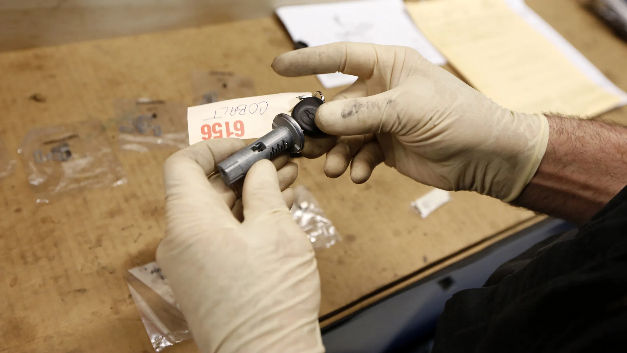 A shop foreman installs tumblers for the key cylinder during recall work on a GM 2005 Chevrolet Cobalt.
