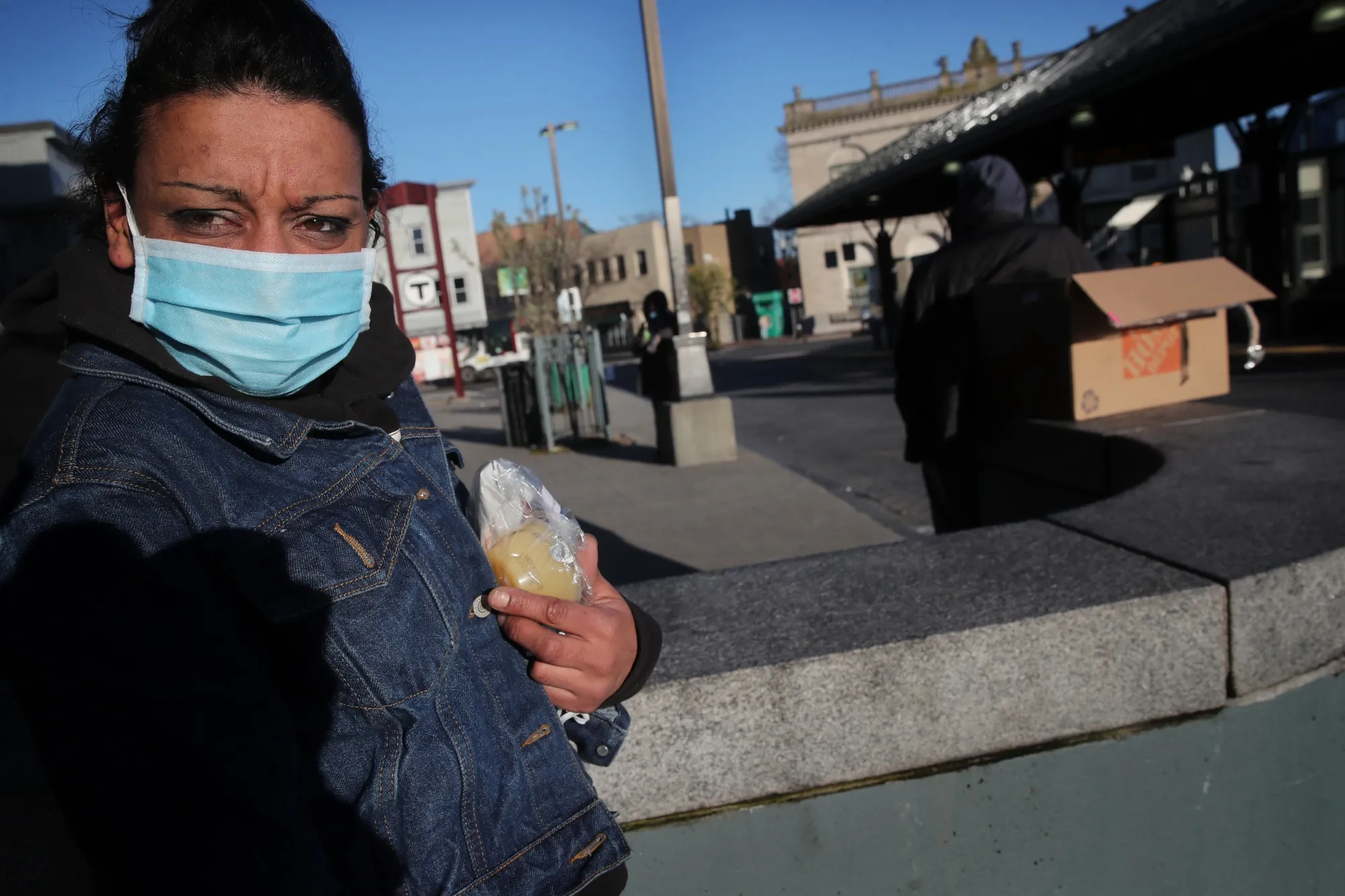 Kerry Seerattan with a face mask she received at a bus station in the Roxbury neighborhood of Boston on April 29..