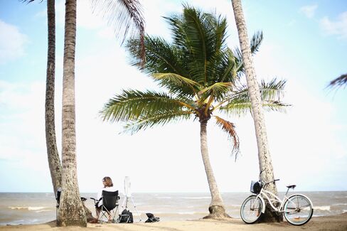 People Sit At Palm Cove Beach