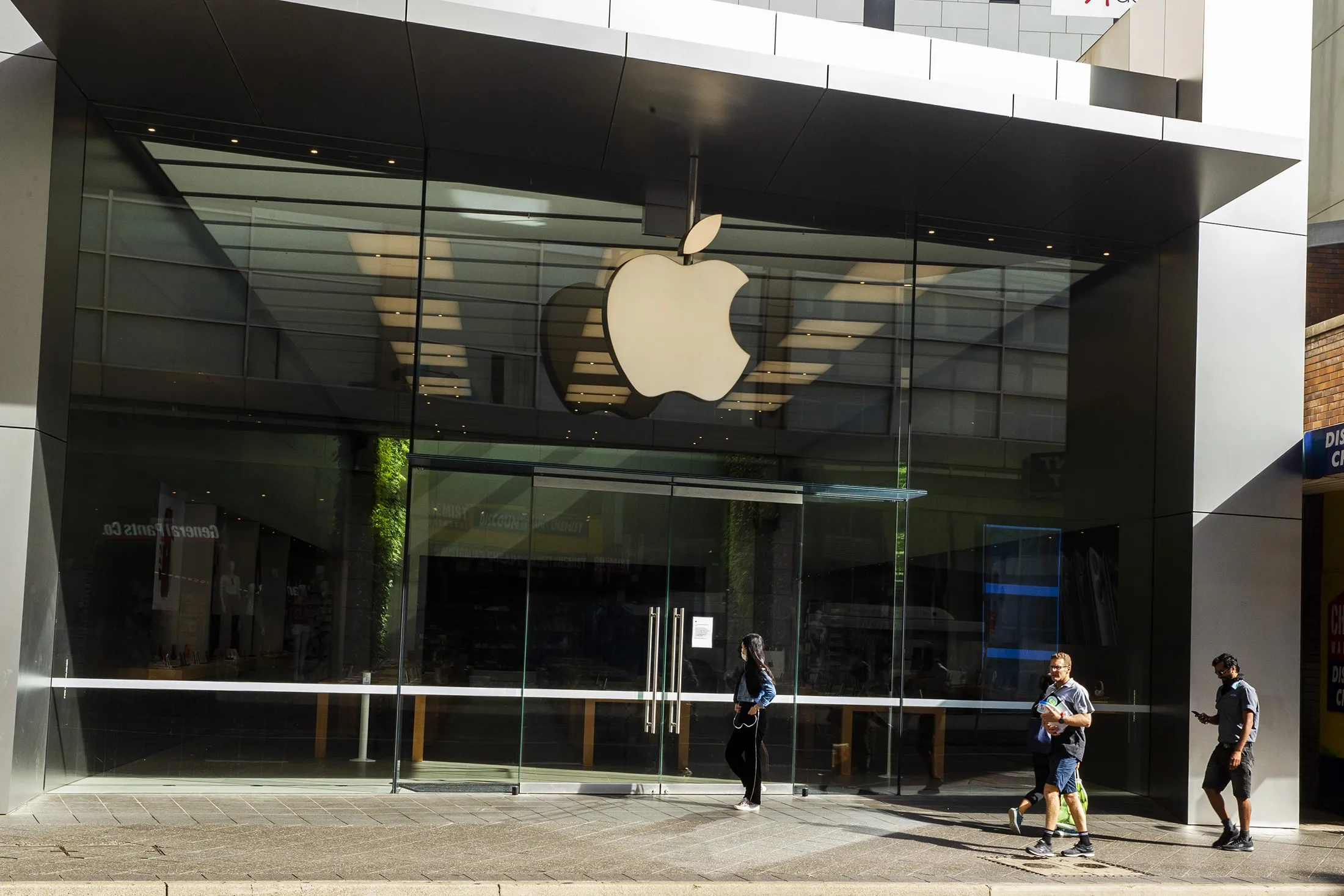 Pedestrians walk past a closed Apple store in Bondi Junction in Sydney, Australia on March 23.