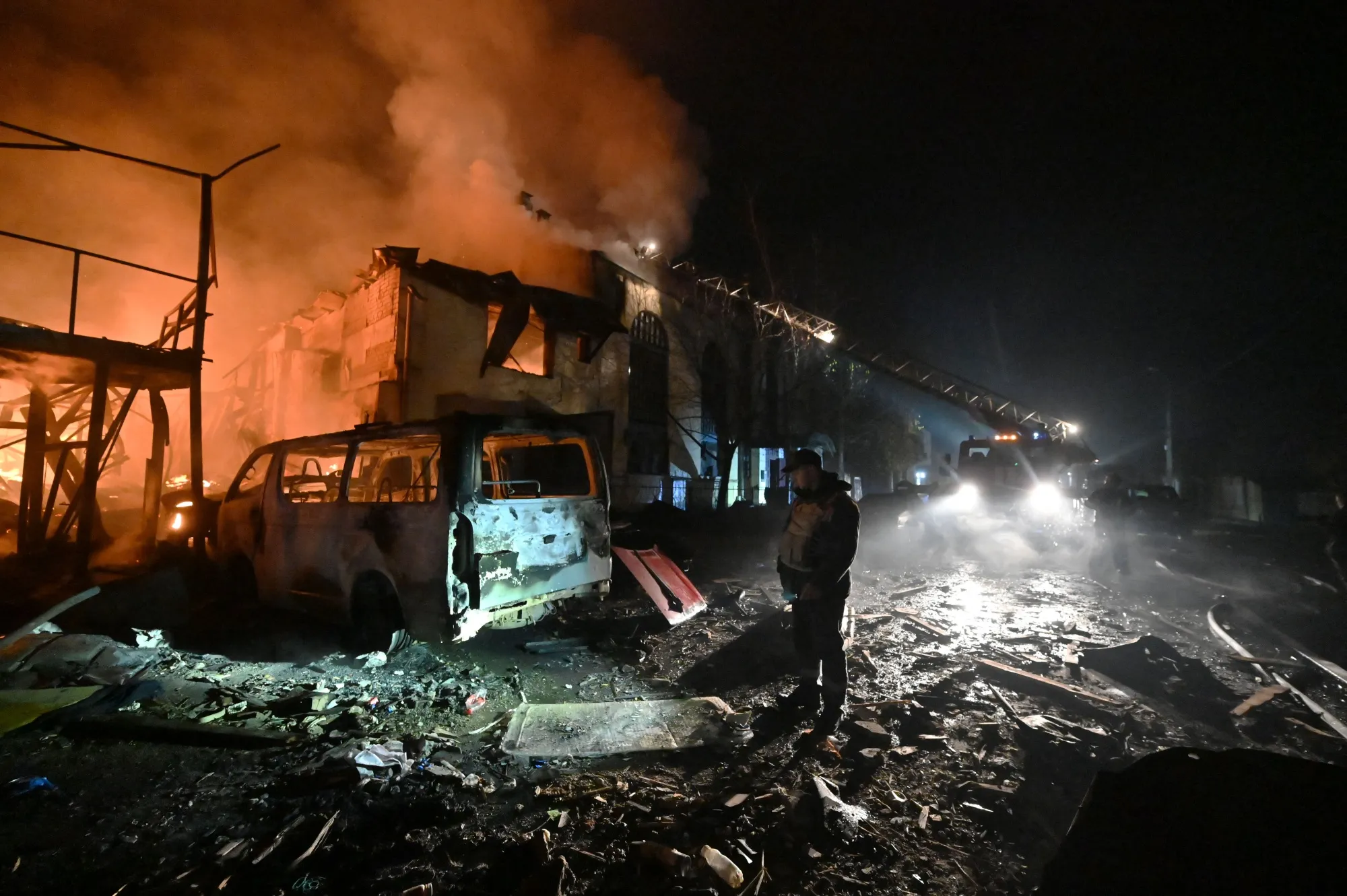 A man looks at the damage as Ukrainian firefighters extinguish a fire following an overnight Russian drone strike in Kharkiv on November 3.