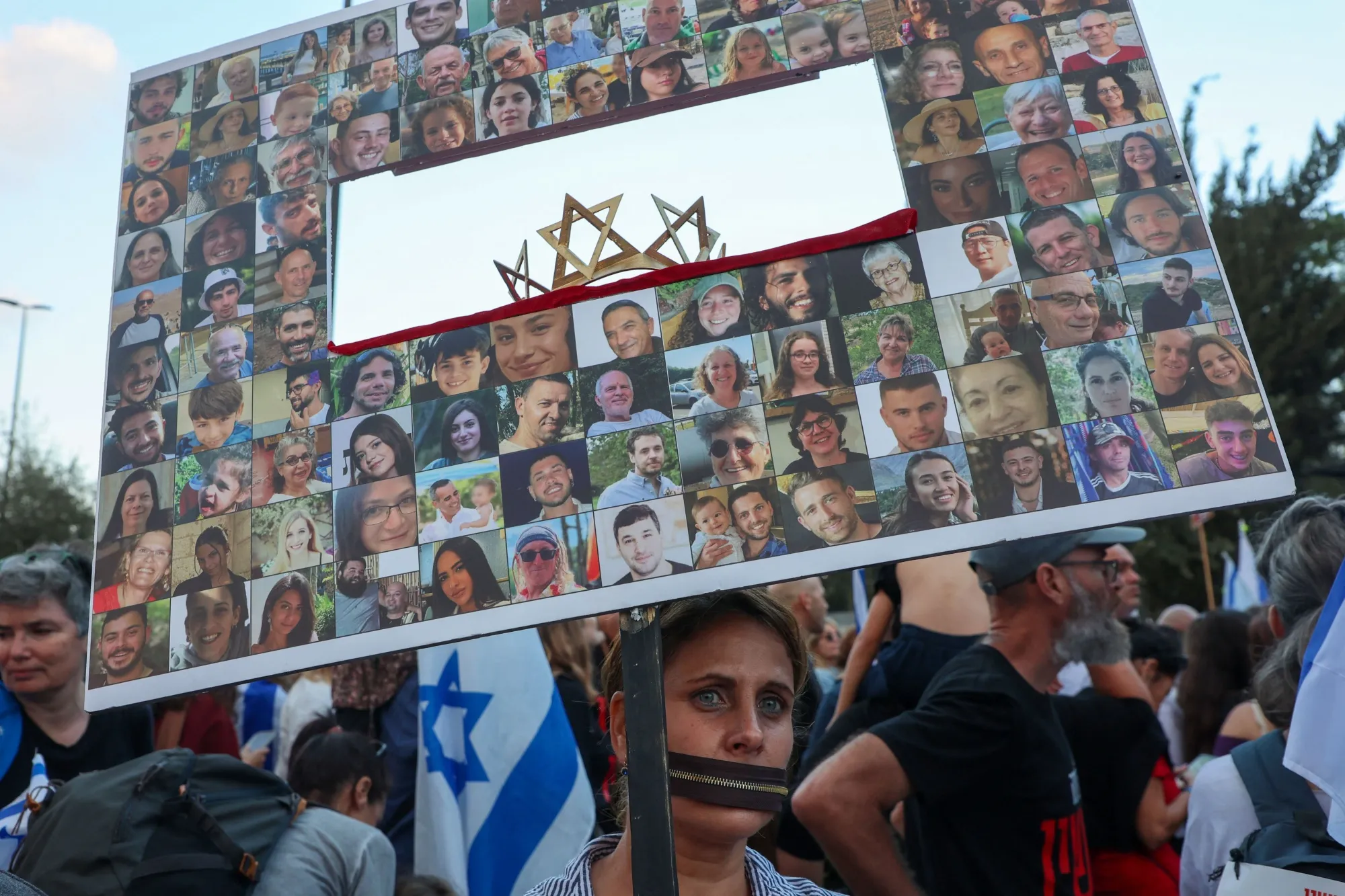 A woman holds holds images of Israeli hostages, held in the Gaza Strip, outside the Prime Minister's office in Jerusalem on Nov. 18.