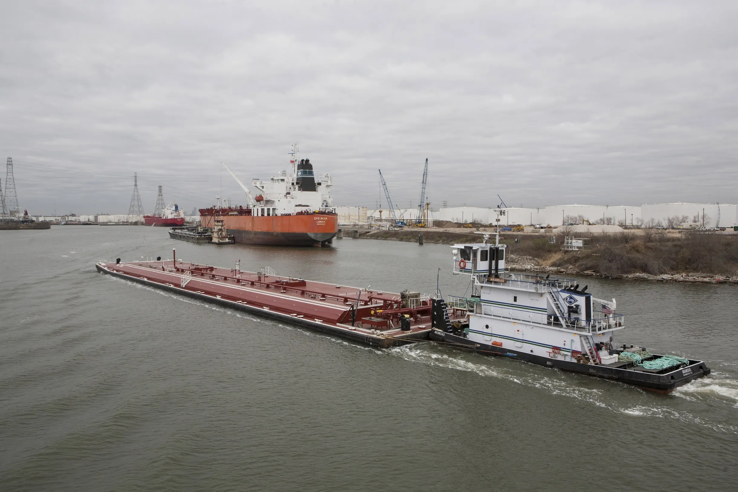 A towboat pushes a barge along the Houston Ship Channel.