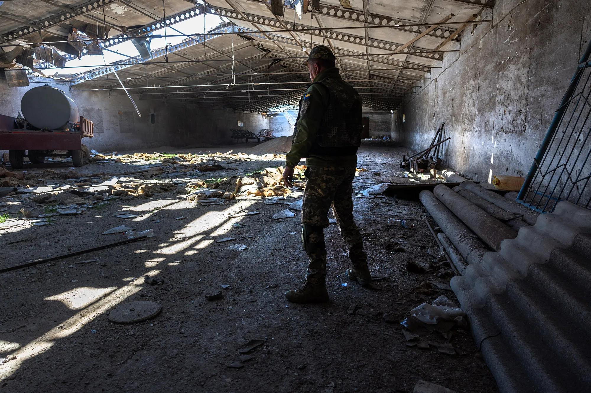 A Ukrainian army officer inspects a grain warehouse shelled by Russian forces, on May 6.