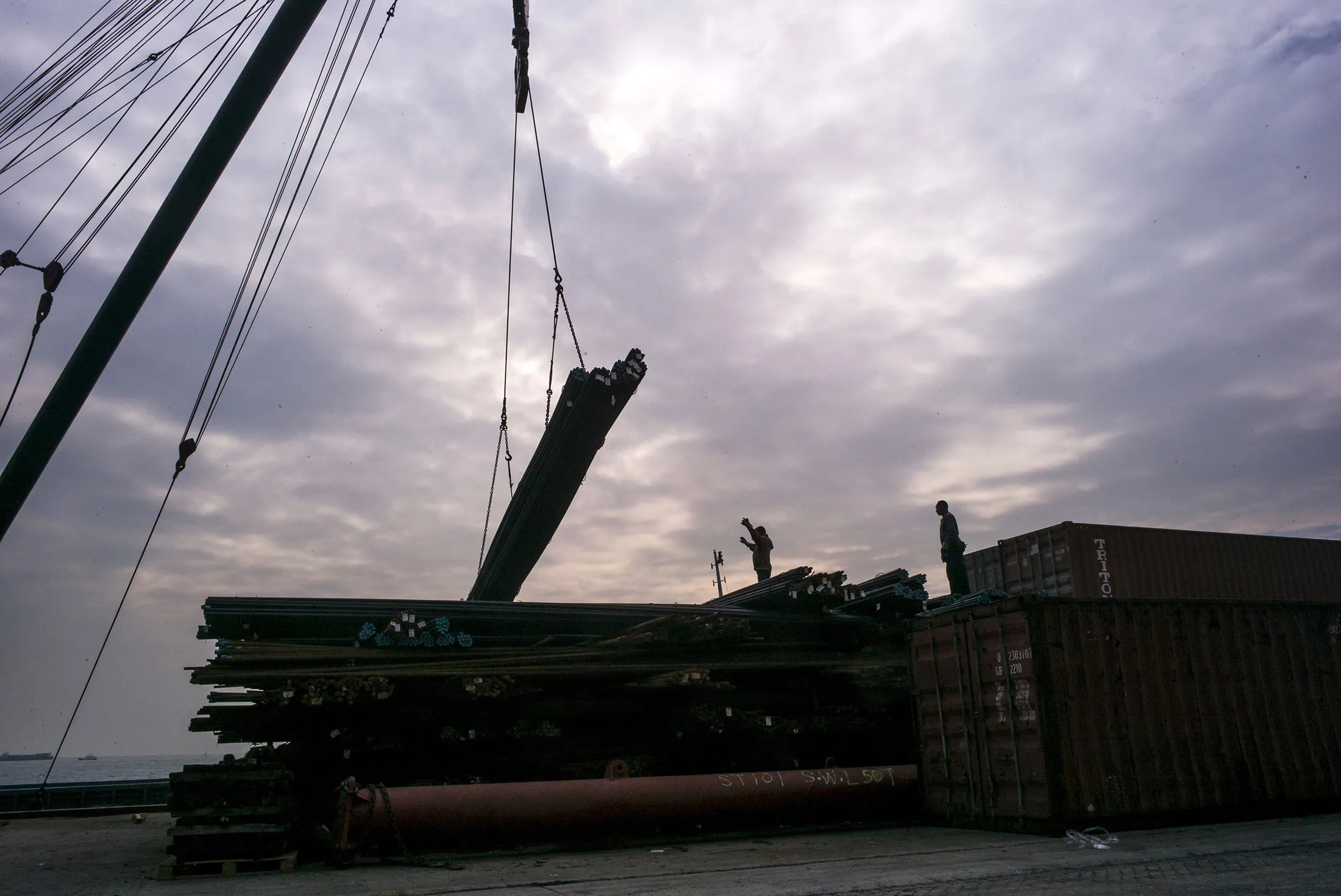 Workers unload steel rods from a ship at the Kwai Tsing Container Terminals in Hong Kong, China, on Dec. 7, 2015.
