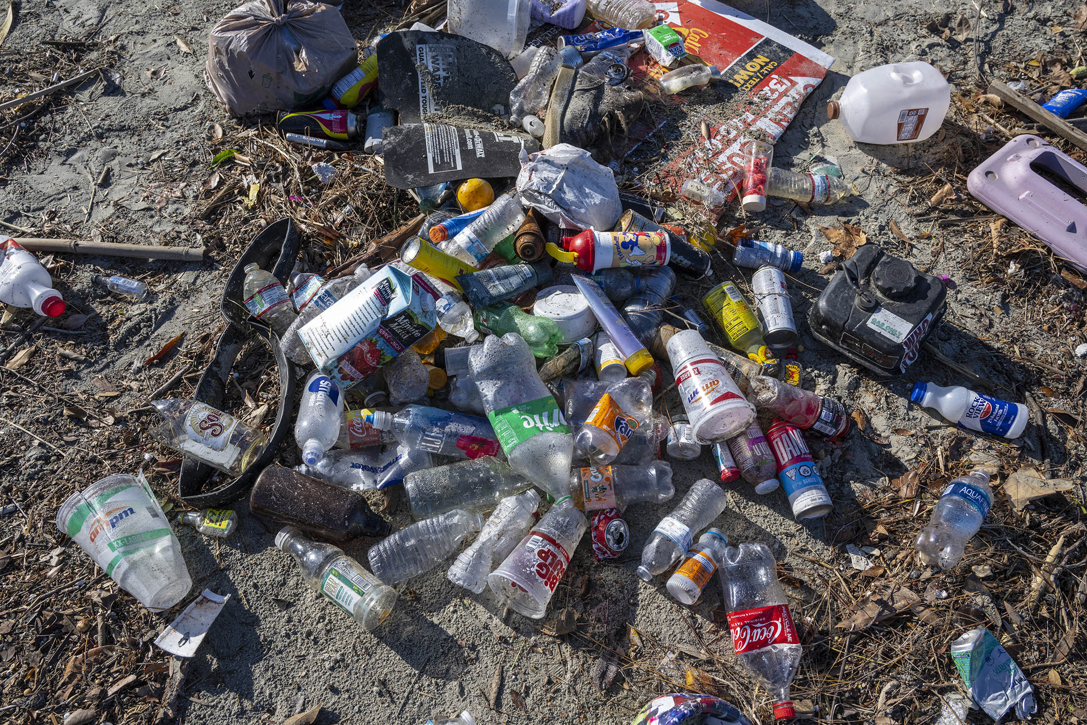 Plastic bottles and other trash washed up on the shore of the San Gabriel River, near the Pacific Ocean, following heavy rains in Seal Beach, California, on Dec. 13, 2022.