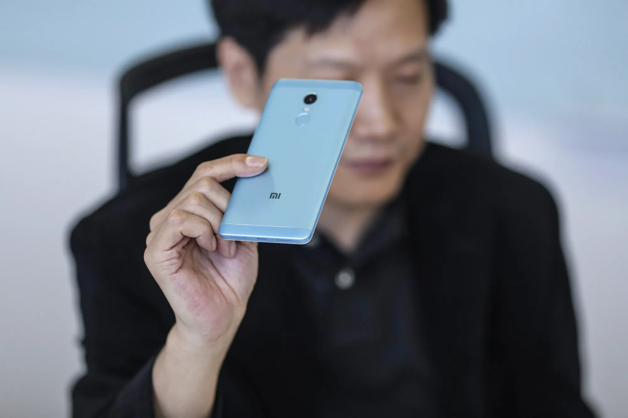 Lei Jun holds up a Xiaomi smartphone.