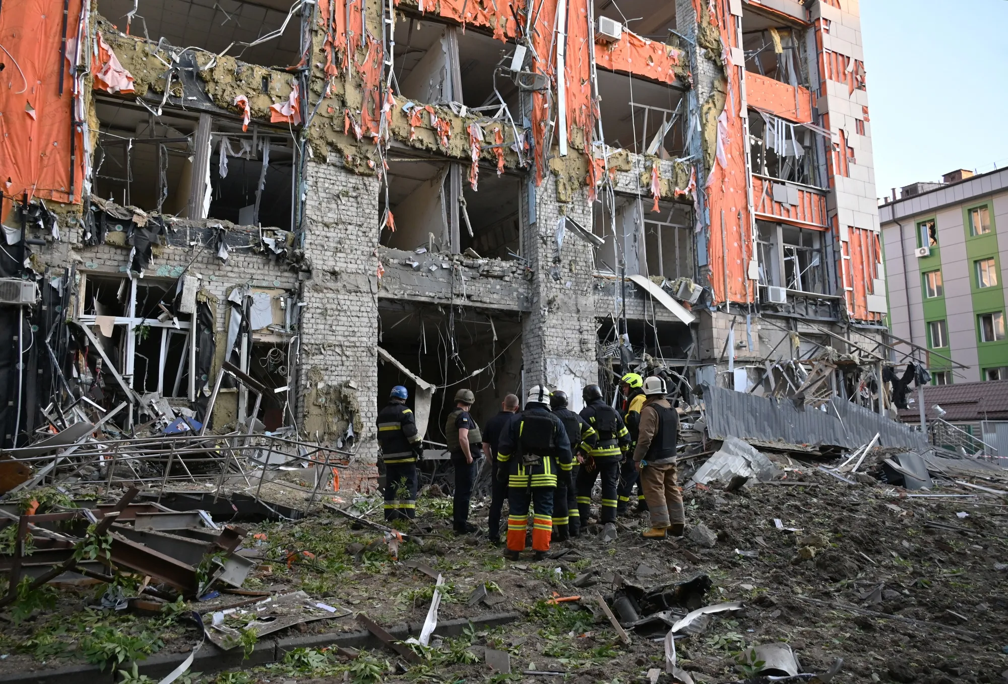 Firefighters inspect a heavily damaged office building following Russian air strike in Kharkiv, on May 25.