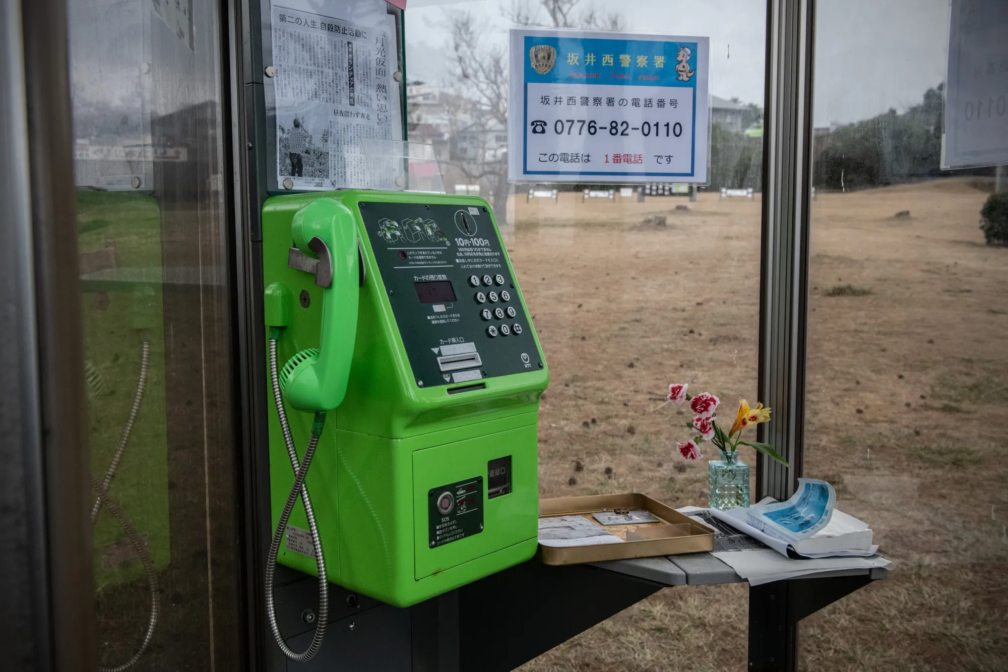 A phone box with numbers for suicide prevention support as well as a bible and messages of support, at Tojinbo cliffs in Japan.