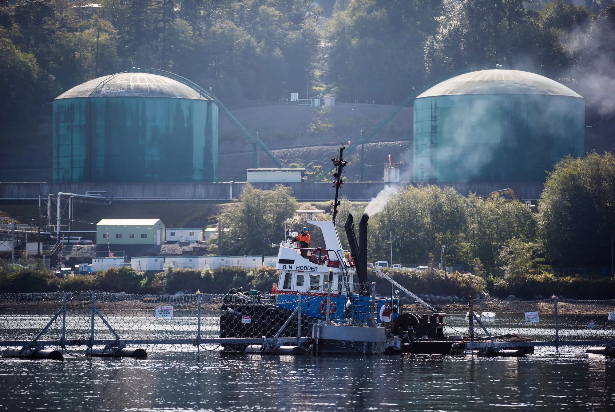 A tugboat secures a fence at the Westridge Marine Terminal, at the end of the Trans Mountain oil pipeline,&nbsp;in Burnaby, British Columbia.
