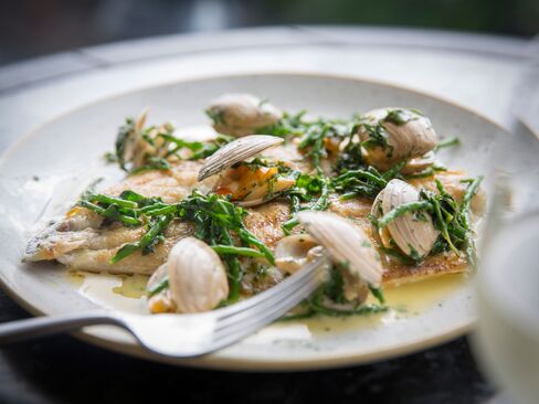 Sea bass is served from the plancha grill, with surf clams and wilted greens.