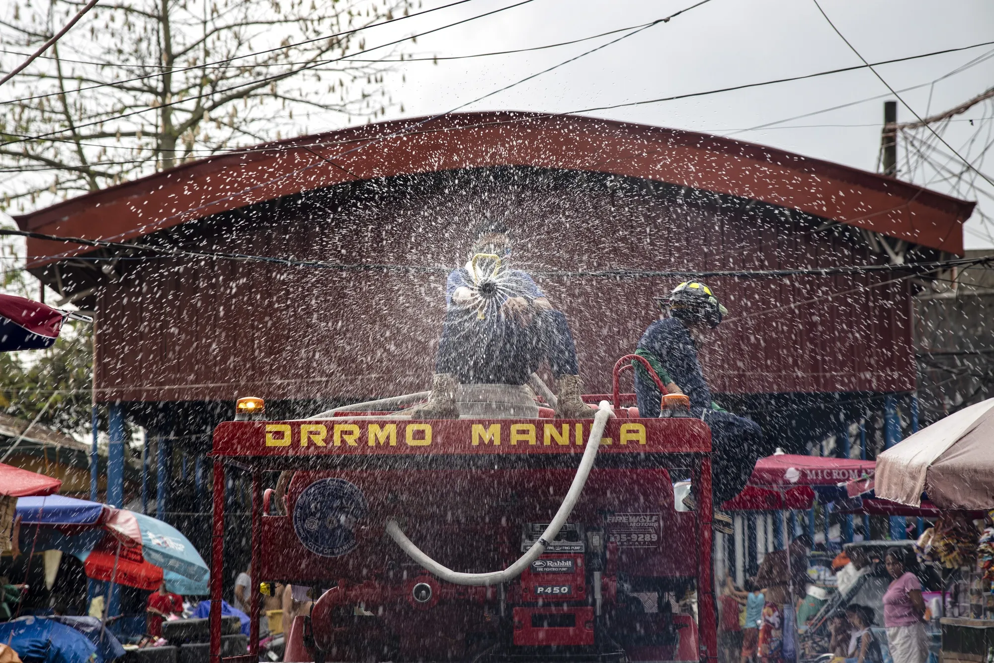 A worker sprays anti-septic solution aboard a firetruck along a street in Manila on March 11.