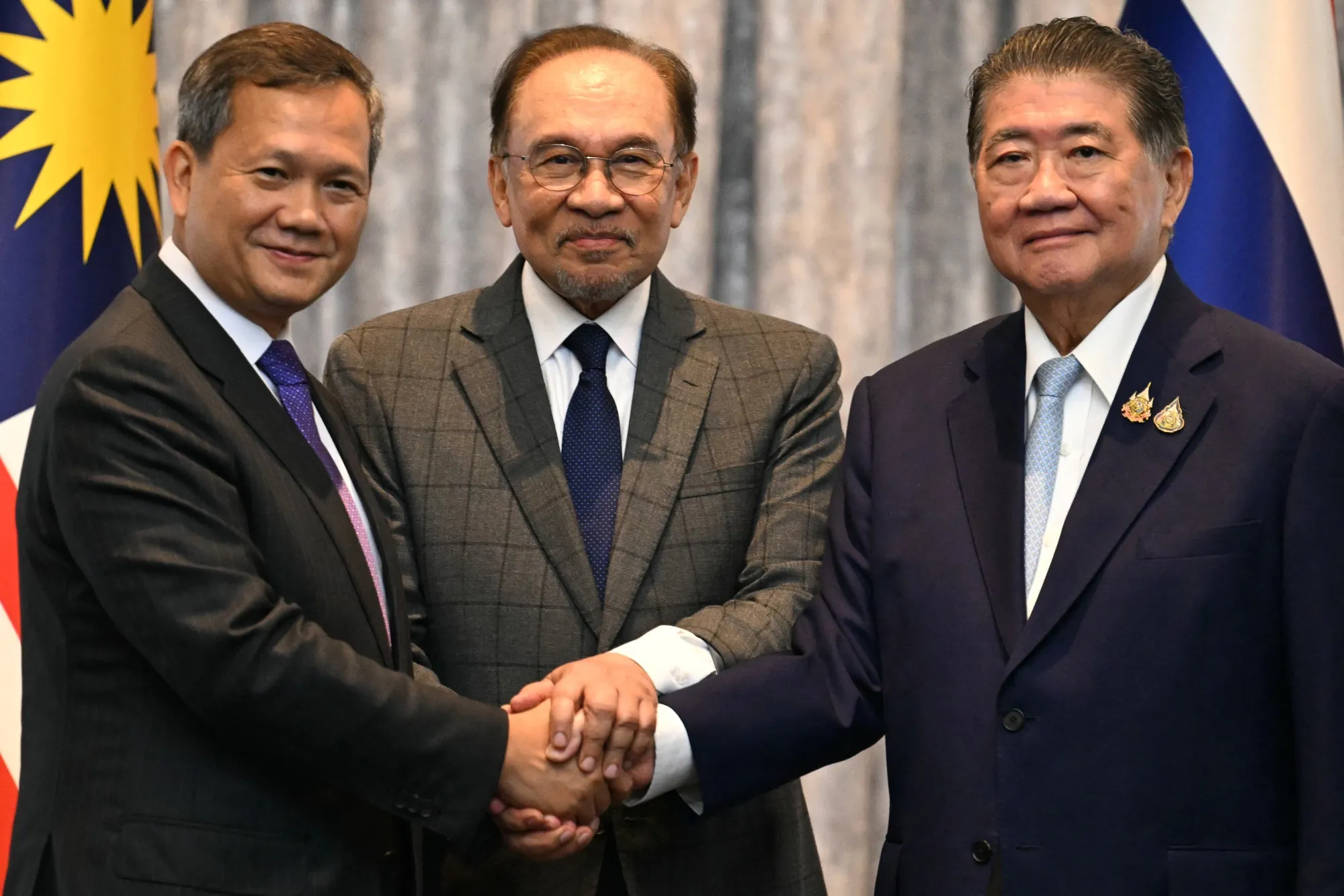 Anwar Ibrahim, center, with Hun Manet, left, and Phumtham Wechayachai in Putrajaya on July 28.