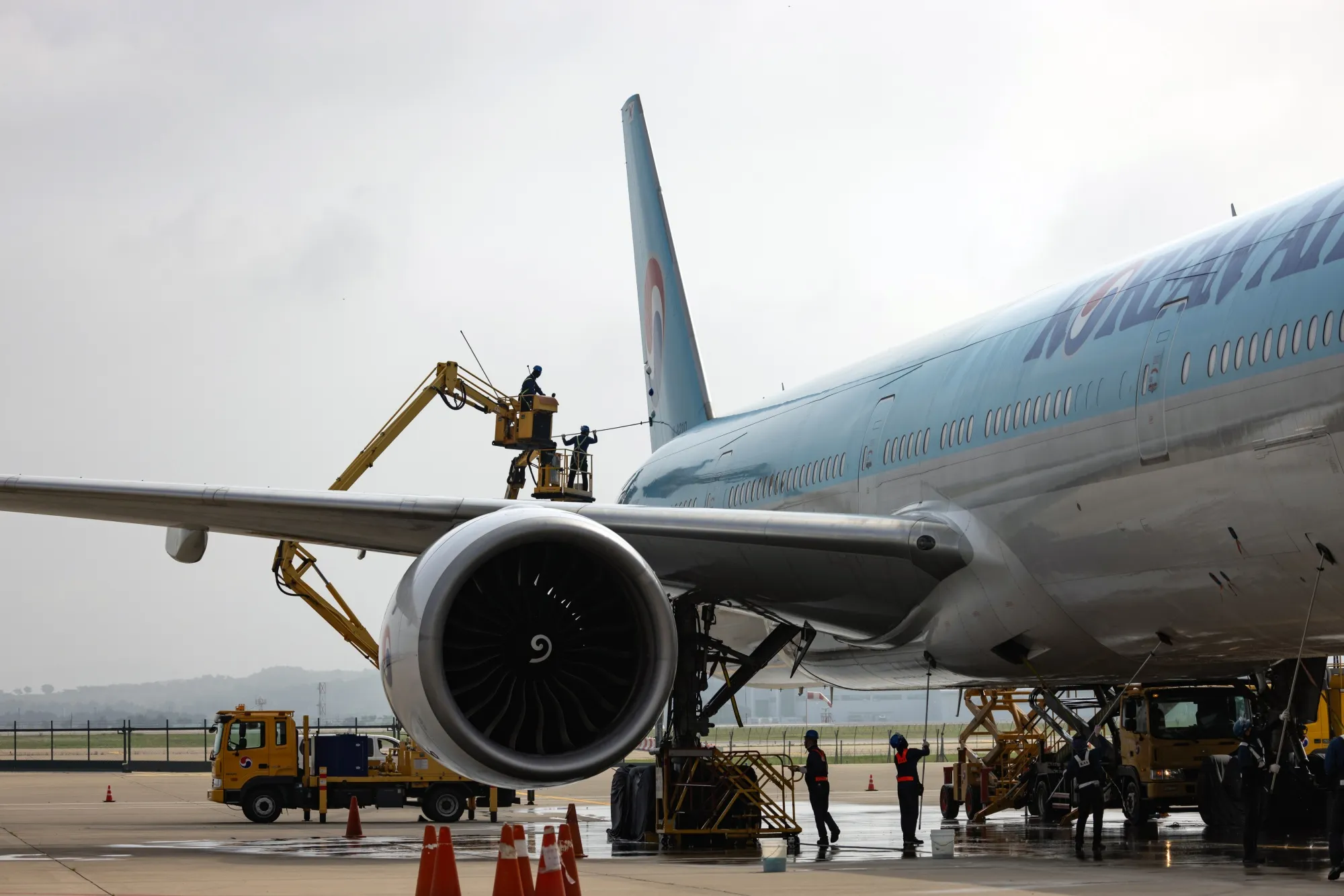 Workers clean a Korean Air Lines Boeing&nbsp;777-300ER passenger aircraft on the tarmac outside the company's hangar at Incheon International Airport in Incheon, South Korea.