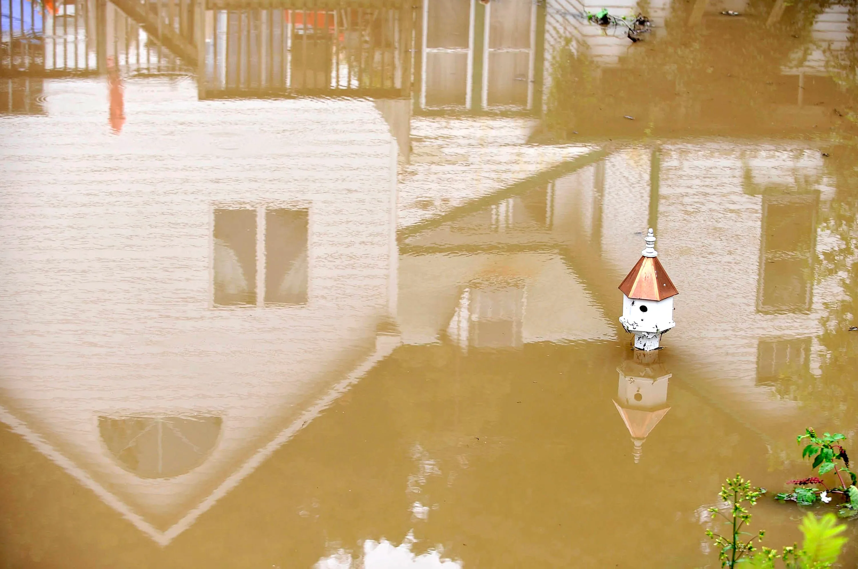 A house in Port Deposit, Maryland, is reflected in the floodwater in the home's backyard that surround a bird house,  on Sept. 9, 2011. Photographer: Kim Hairston/Baltimore Sun/MCT via Getty Images