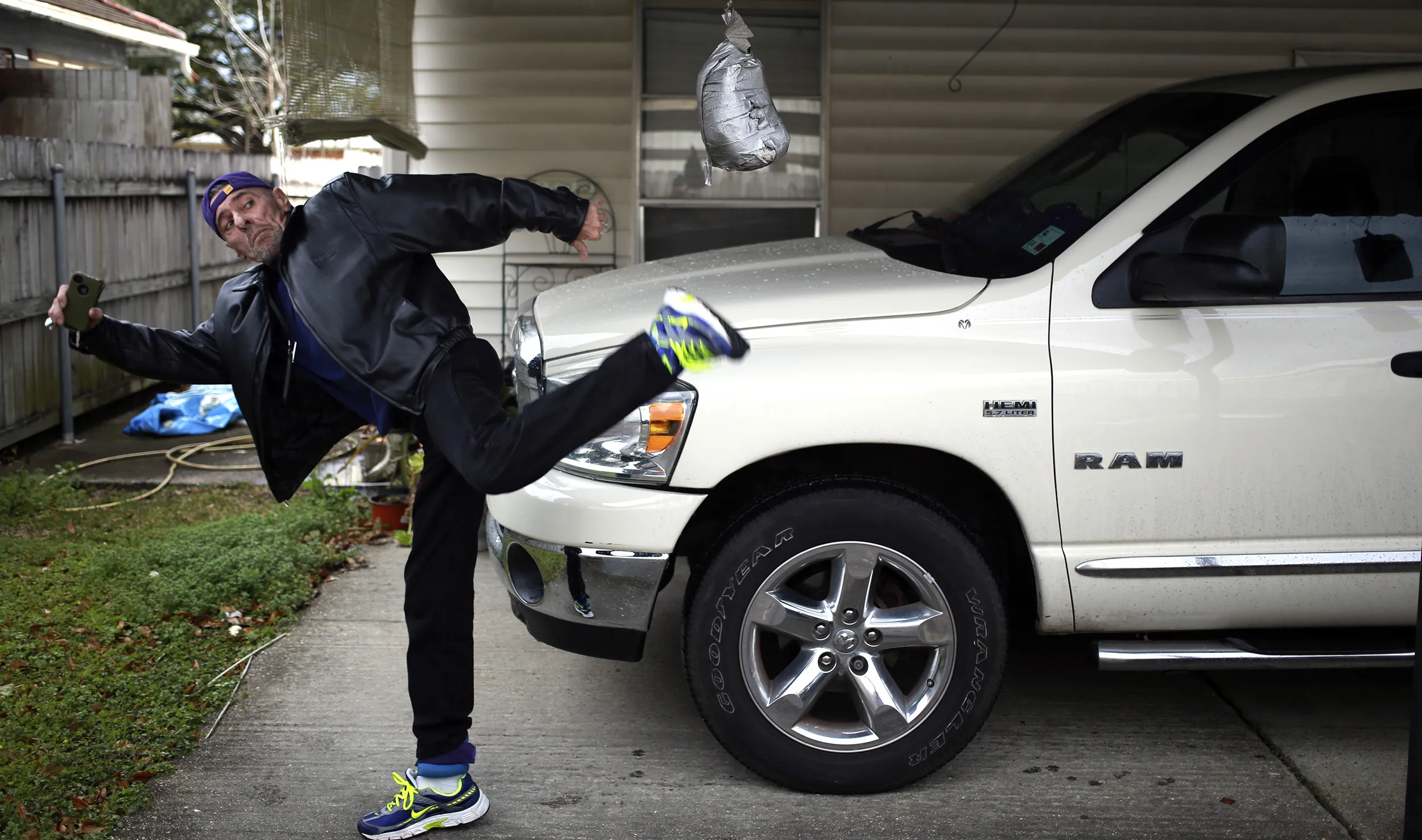 Cancer patient Tom Galjour high-kicks a punching bag outside his apartment in Houma, Louisiana, on Feb. 3, 2015.
