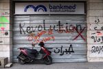 The word 'Revolution' is sprayed on a shuttered BankMed SAL bank branch in Beirut.