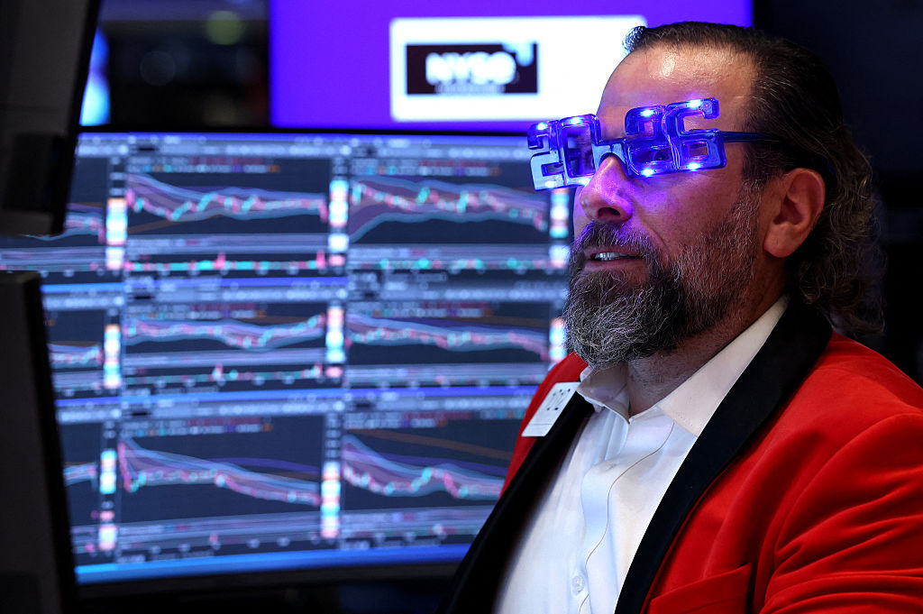 Trader Michael Pistillo wears "2026" glasses as he works on the floor of the New York Stock Exchange (NYSE) at the opening bell in New York on December 31, 2025. Wall Street's main indexes pulled back slightly on Wednesday, in a mild retreat that still sets the stage for a robust showing for all of 2025. (Photo by TIMOTHY A. CLARY / AFP via Getty Images)
