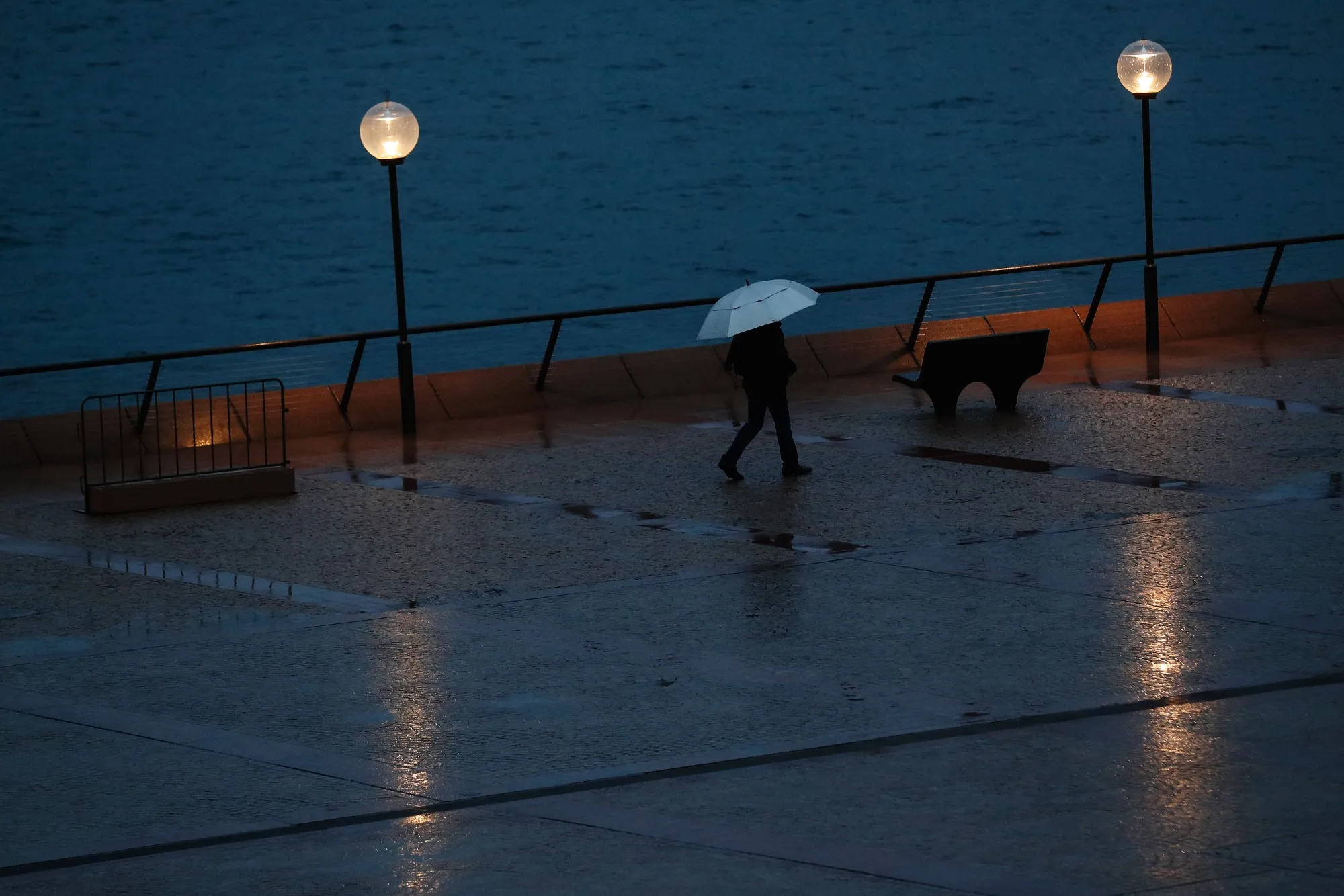 A pedestrian walks along the Sydney Opera House forecourt during a partial lockdown in Sydney on April 3.