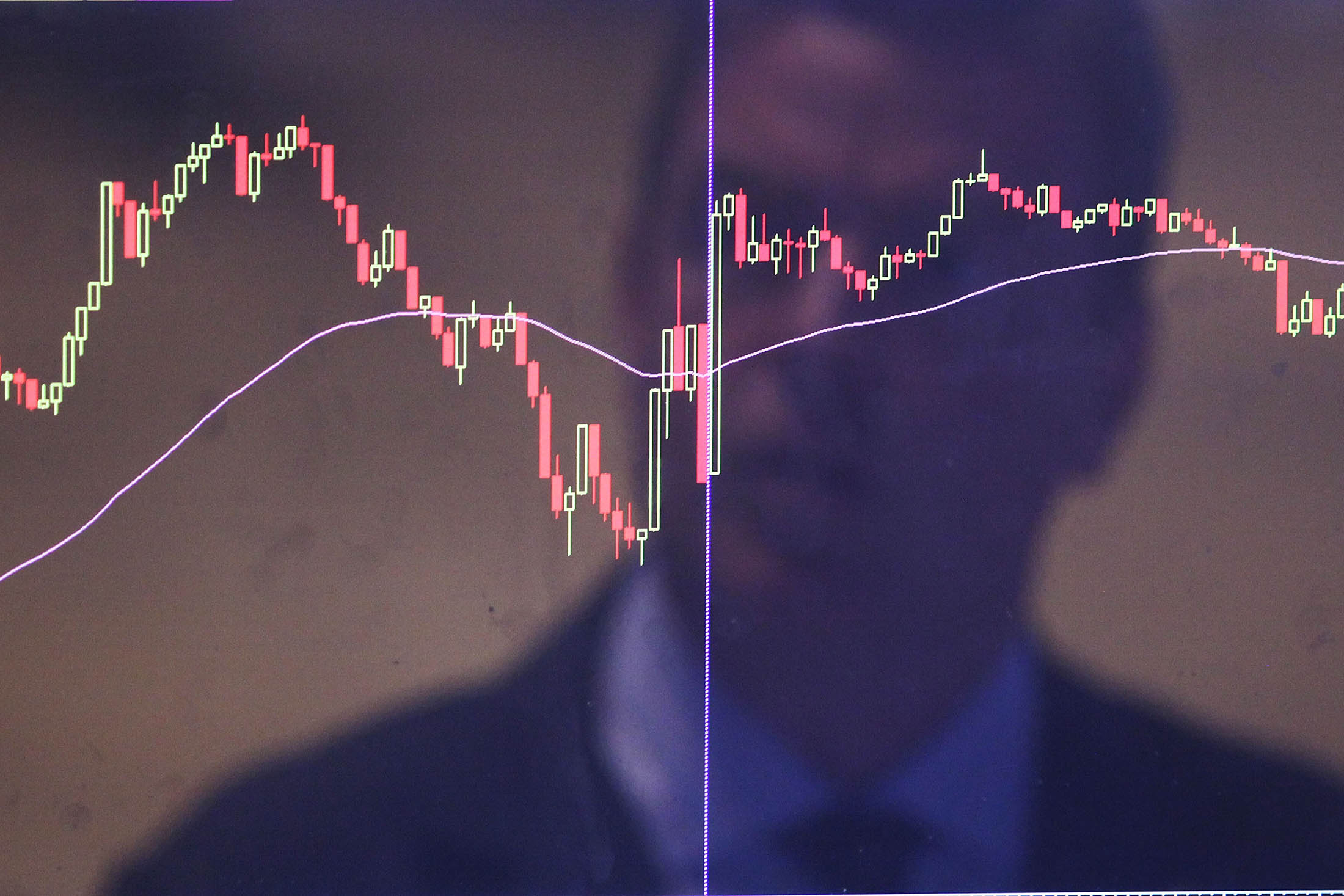NEW YORK, NY - AUGUST 25: A trader is reflected in a market screen on the floor of the New York Stock Exchange (NYSE) on August 25, 2015 in New York City. Following a day of steep drops in global markets, the Dow Jones industrial average rallied early in the day only to fall over 200 points at the close.
