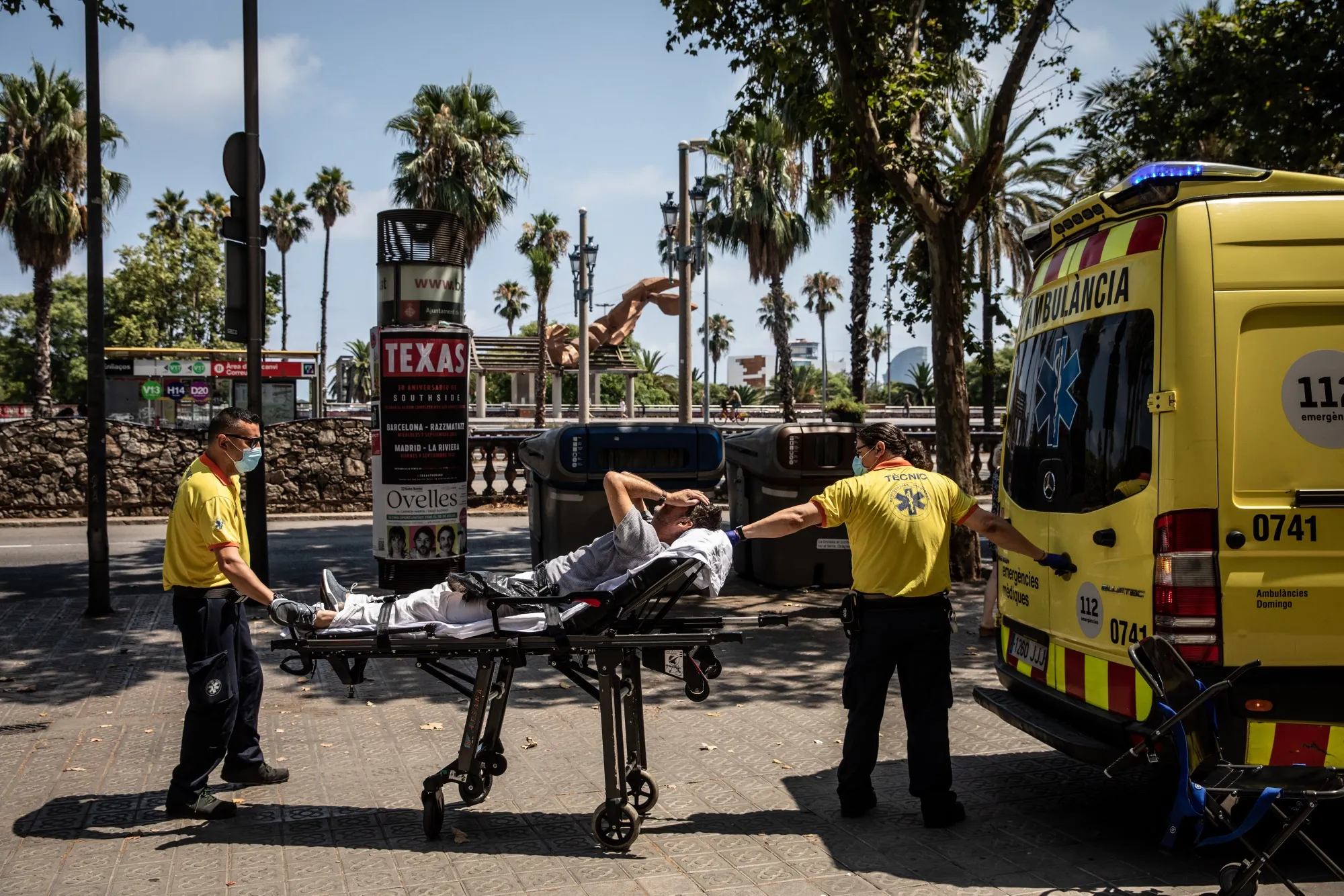 Paramedics help a patient into an ambulance during a heat wave in Barcelona, 2022.