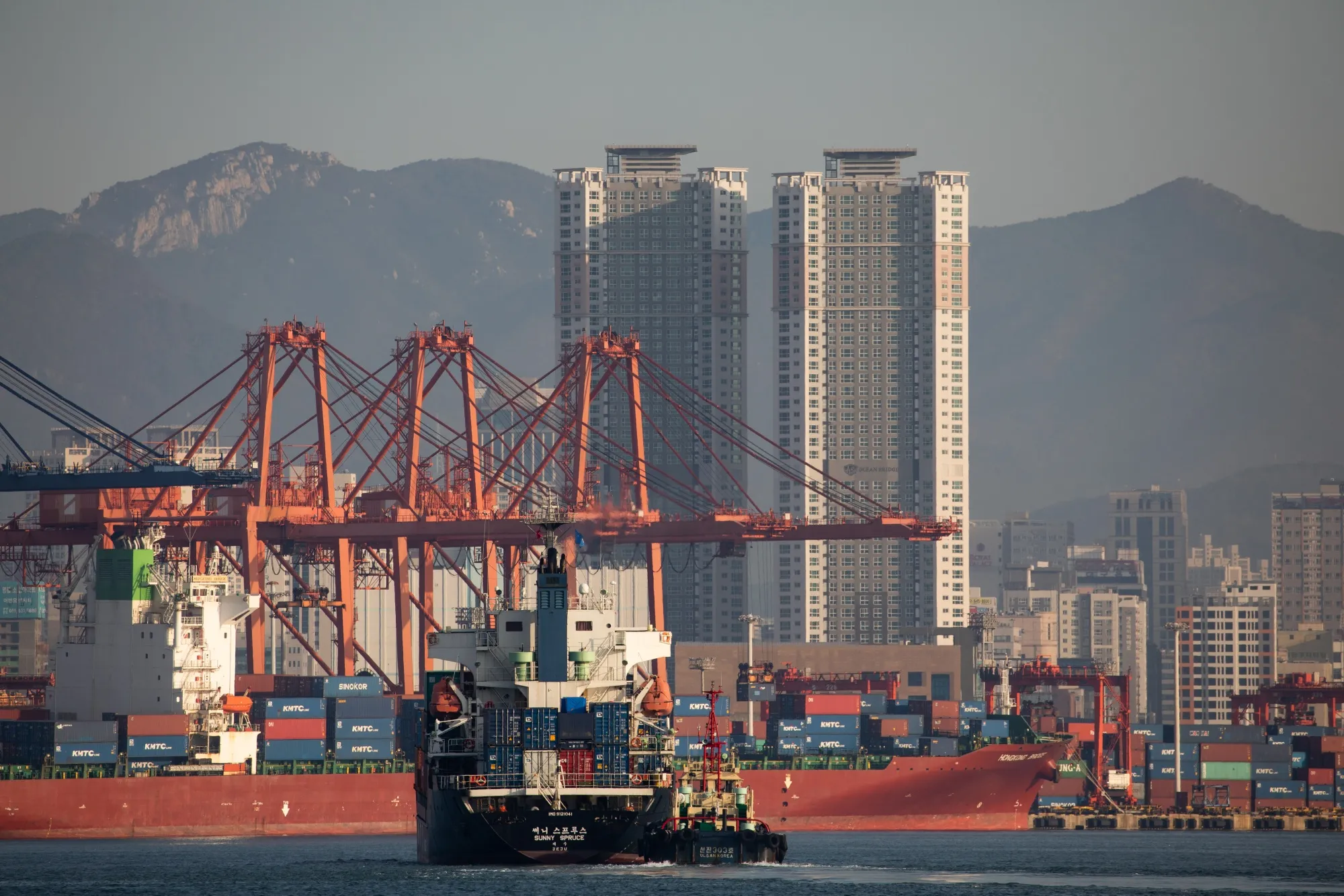 A container ship is towed by a tug boat at the Port of Busan in Busan, South Korea.