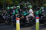 Riders and passengers on Go-Jek motorcycles in Jakarta.