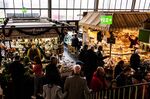 Shoppers browse food stalls at an indoor market in Frankfurt, Germany.