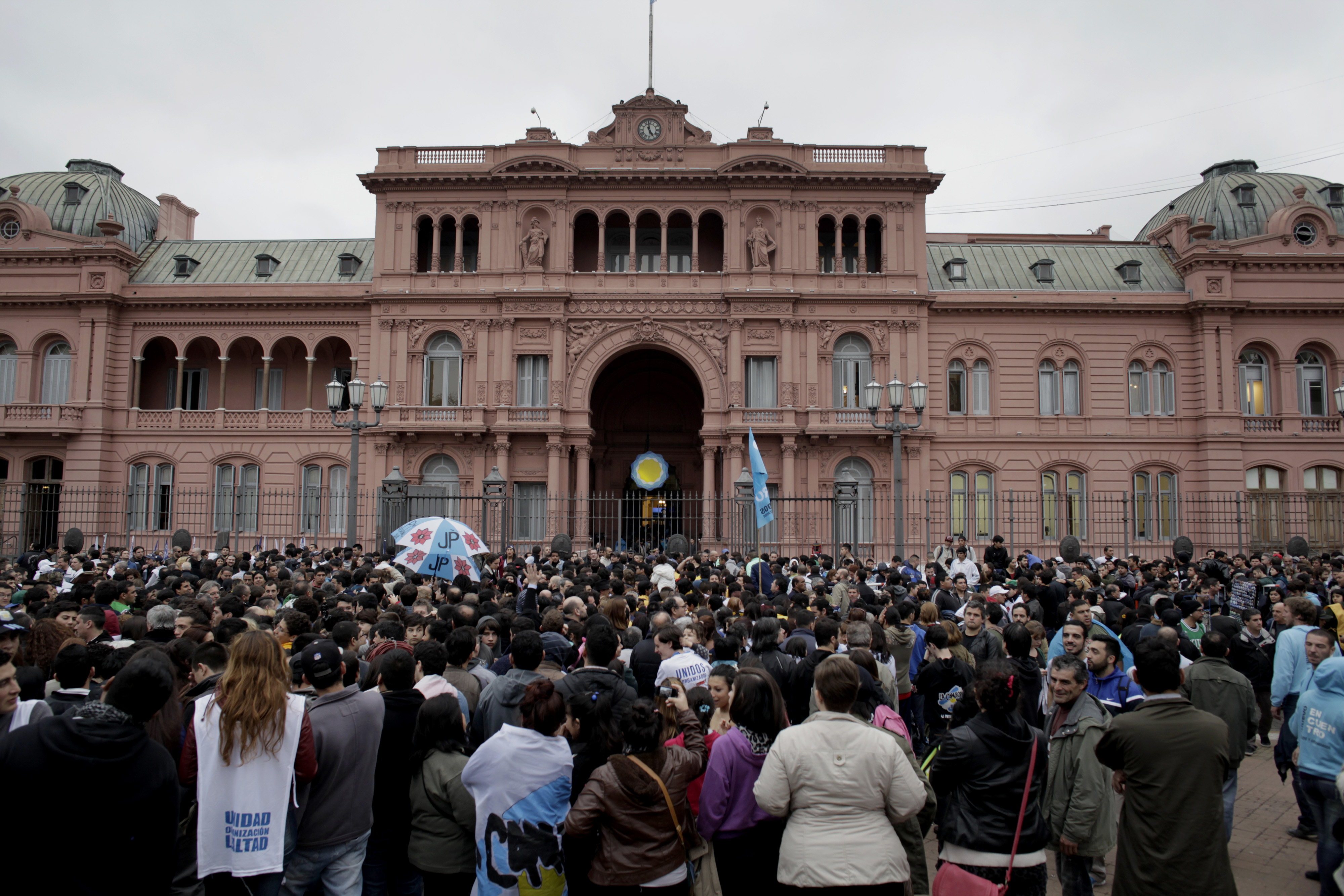 People stand outside the Pink House, the residence of Argentinian presidents past and present. Photographer: Diego Levy/Bloomberg
