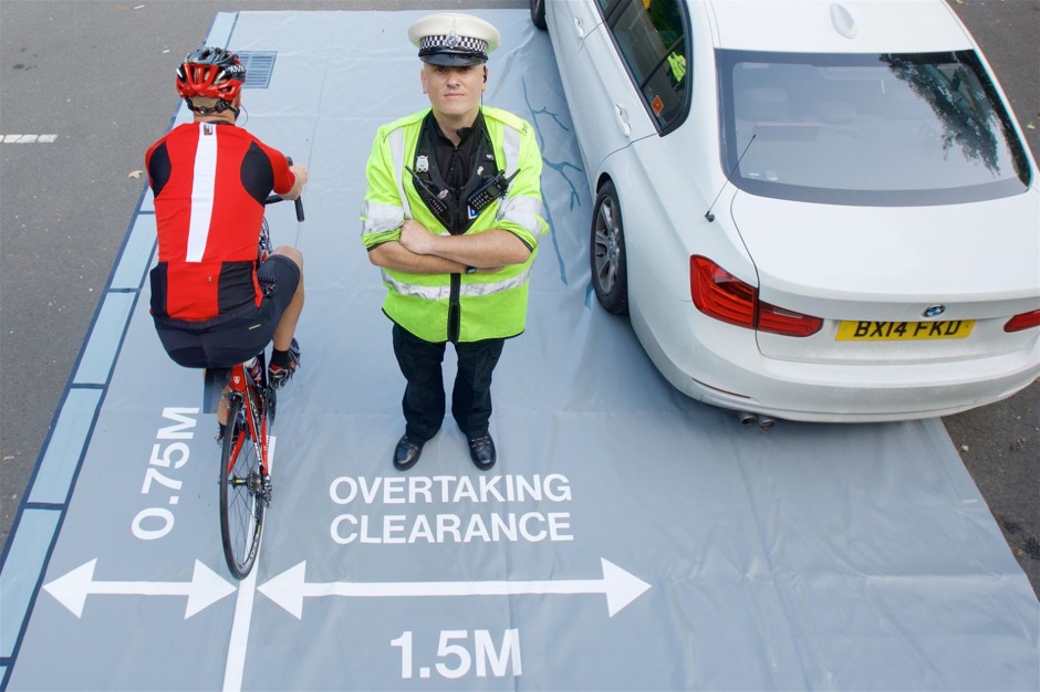 A police officer demonstrating the safe distance for overtaking clearance