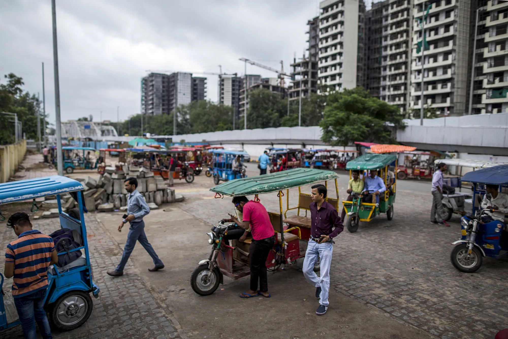 E-rickshaw pullers await passengers at a metro station in New Delhi.
