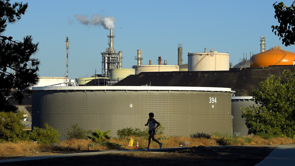 A jogger runs in front of the Phillips 66 refinery in the Wilmington neighborhood of Los Angeles.