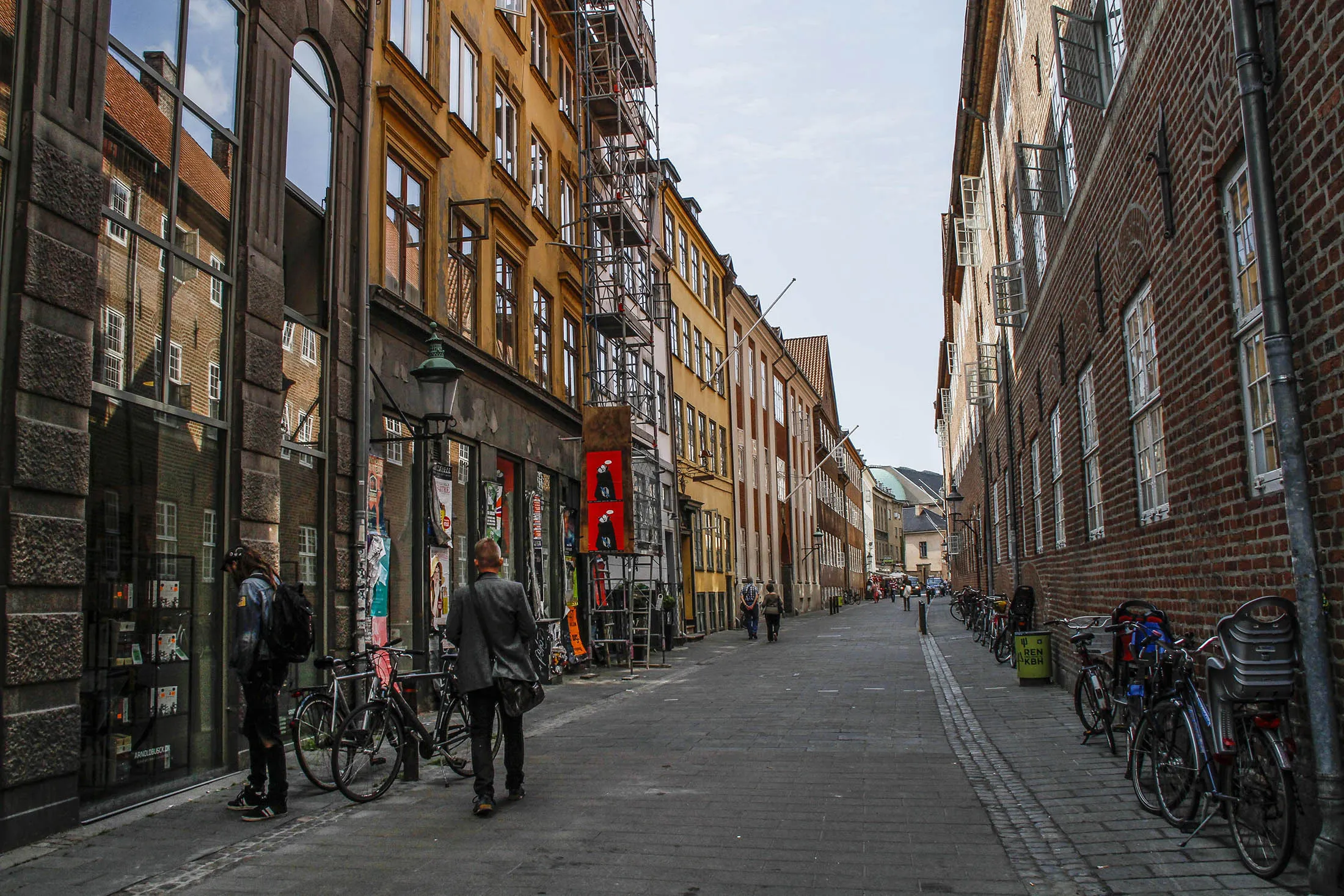 Pedestrians pass along a street lined with commercial and residential buildings in central Copenhagen, Denmark, on Thursday, Aug. 22, 2013. Danes, the world's most indebted people, have hesitated to spend after house prices plunged about 20 percent since their 2007 peak.
