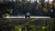 A tractor sprays agricultural fields with glyphosate.