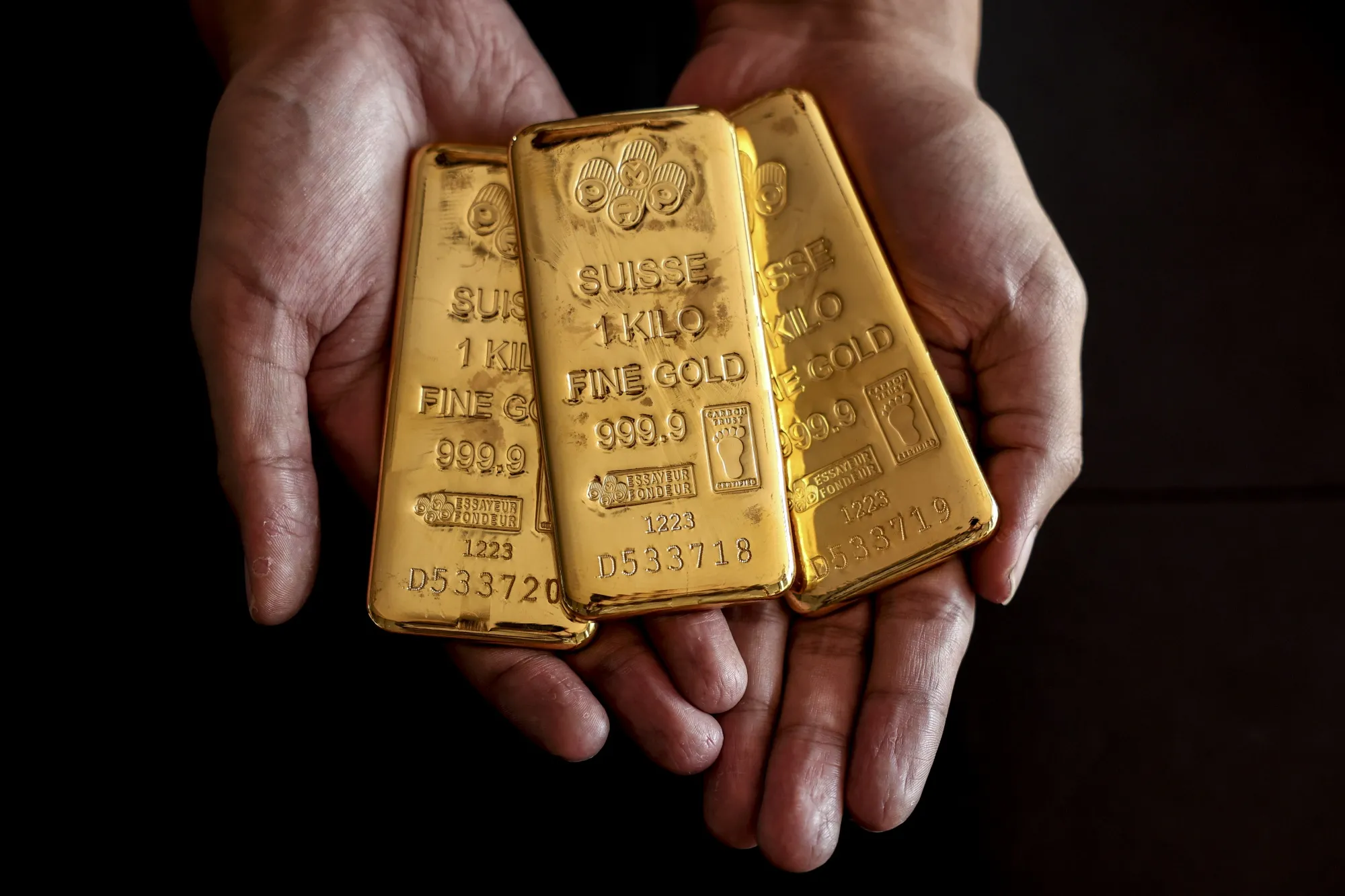 An employee holds one kilogram gold bullions at the YLG Bullion International Co. headquarters in Bangkok, Thailand.
