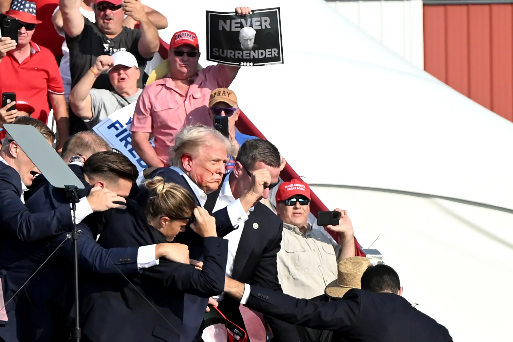 Former US President Donald Trump surrounded by Secret Service agents during a campaign event in Butler, Pennsylvania.