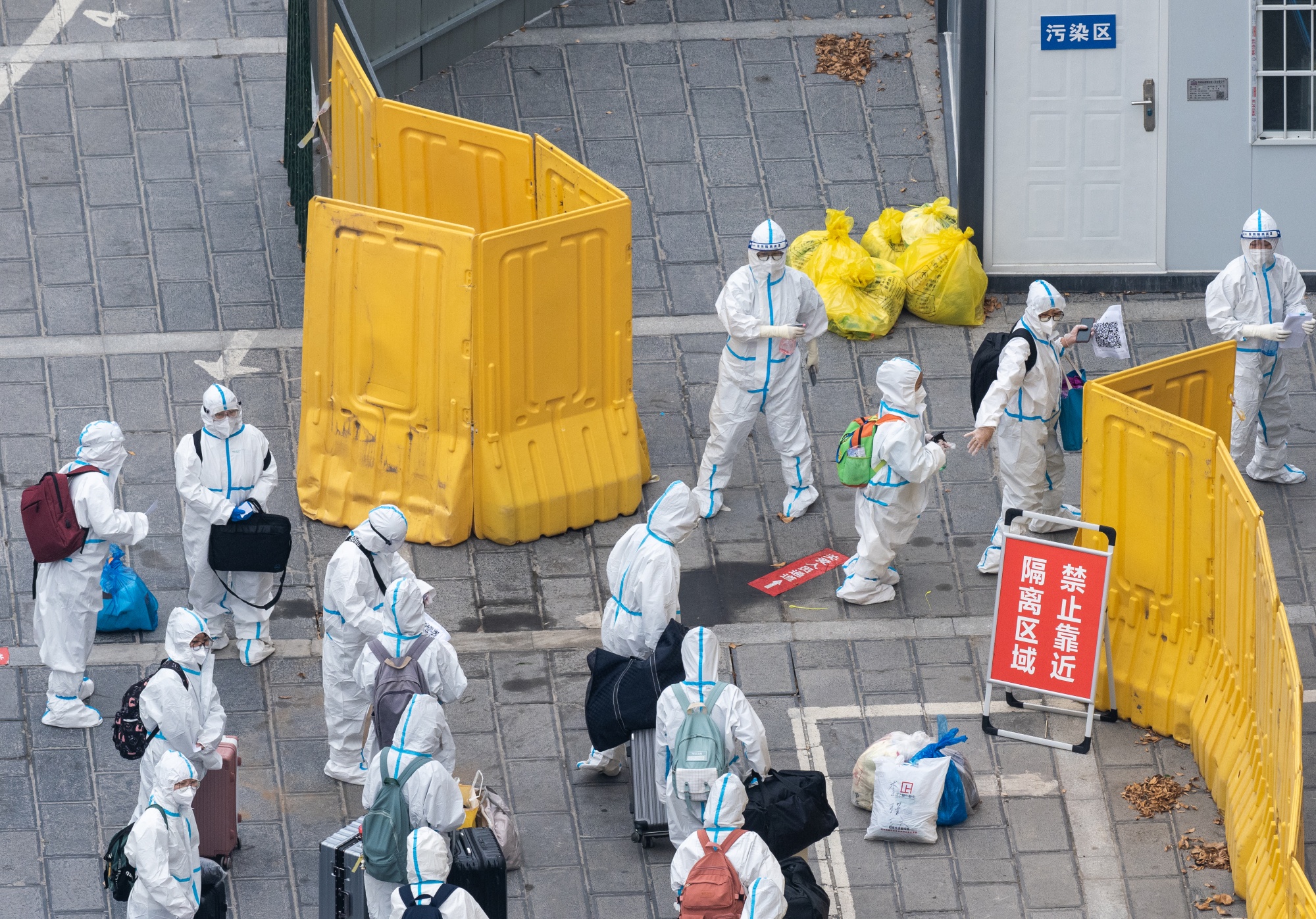 Residents in protective suit enter a specialized hotel for medical observation and quarantine in Zhengzhou on Nov. 1.