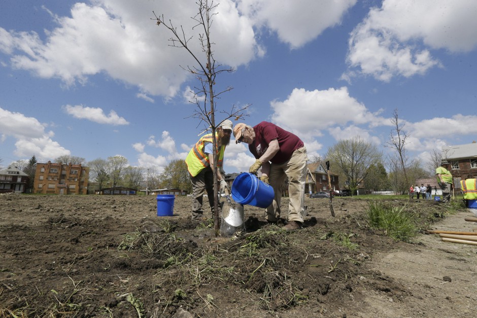 John Kost, left, and Barry Johnson, citizen foresters for the nonprofit group The Greening of Detroit, plant a tree in the Osborn neighborhood in Detroit in 2016.