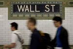 Commuters walk down a subway platform at the Wall Street stop in New York, U.S.
