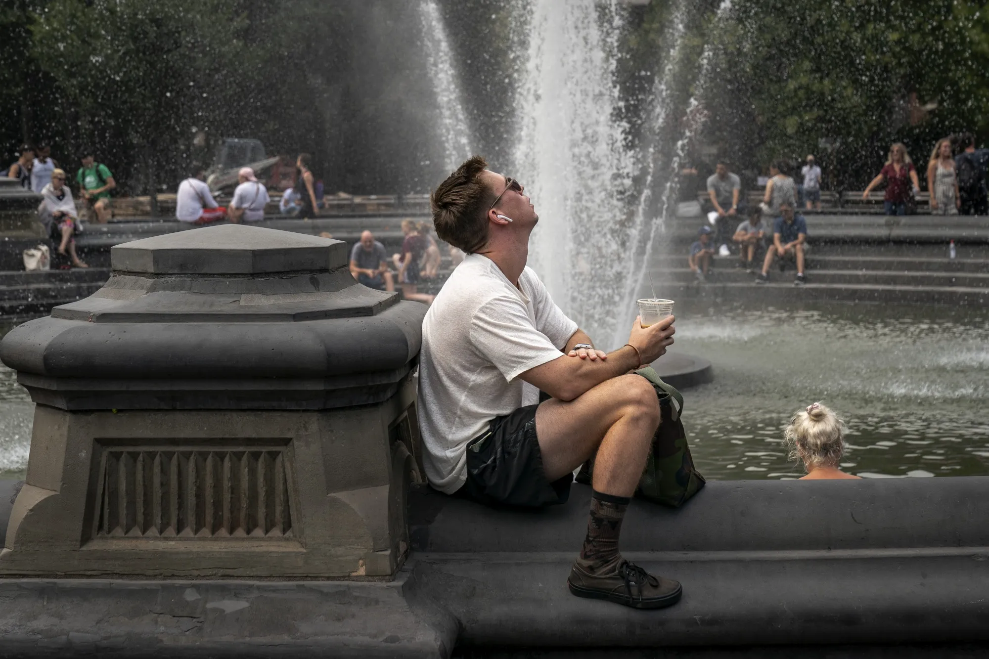 People cool off near the fountain at Washington Square Park, New York on July 17.