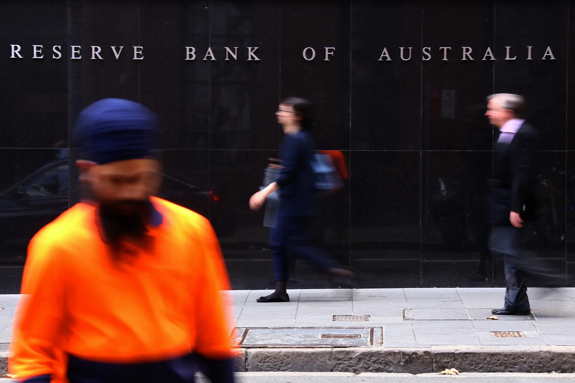 Pedestrians walk past the Reserve Bank of Australia (RBA) headquarters in the central business district of Sydney, Australia.