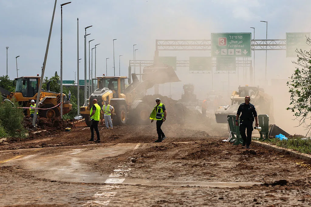 Israeli emergency services clear a road outside Ben Gurion airport after a missile struck near the facility on May 4,&nbsp;
