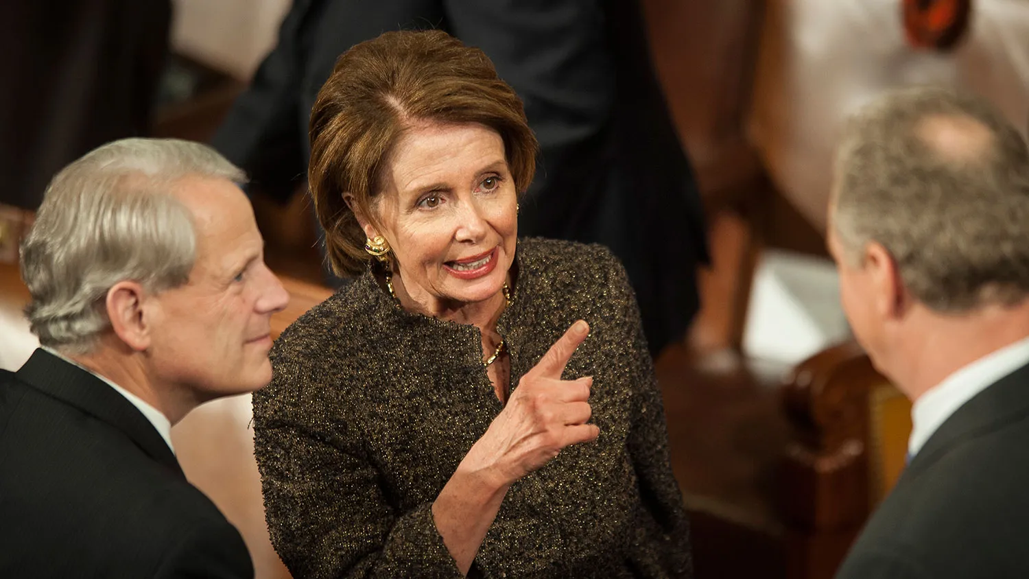 House Minority Leader Nancy Pelosi, center, a Democrat from California, center, points as she talks with members of Congress on the House floor before U.S. President Barack Obama delivers the State of the Union address to a joint session of Congress at the Capitol in Washington, D.C., U.S., on Tuesday, Jan. 20, 2015.

