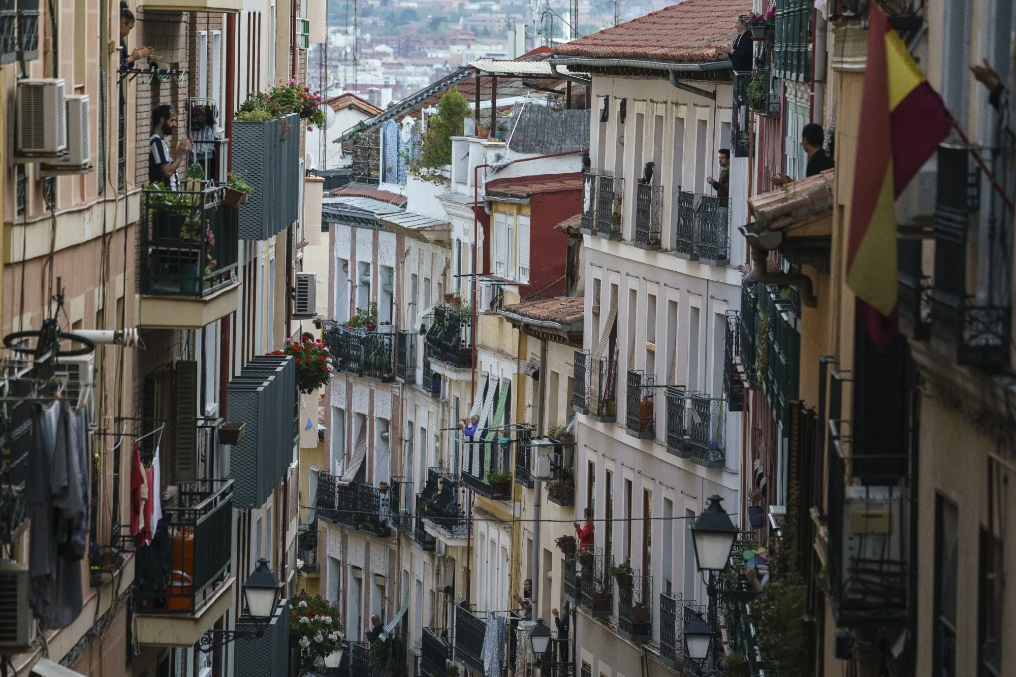Residents gather on balconies of residential homes to perform an applause in recognition of national health workers in the Lavapies neighborhood of Madrid, Spain, on Monday, April 13, 2020. Italy, Spain and France reported a slowdown in new coronavirus cases, allowing governments in Europe to look for ways to safely ease lockdowns that are strangling the region’s economy.