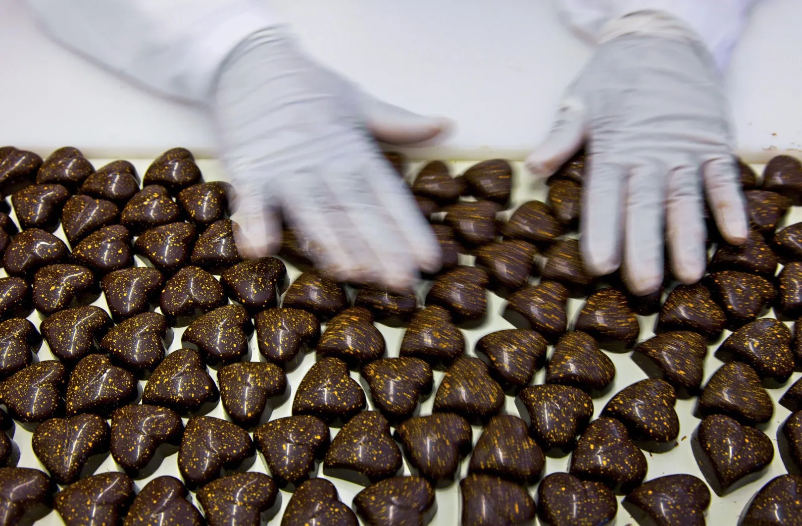 A employee checks Lindt chocolates on the production line at the Lindt &amp; Spruengli AG factory in Kilchberg.