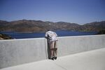 A man peers over the newly raised San Vicente Dam.