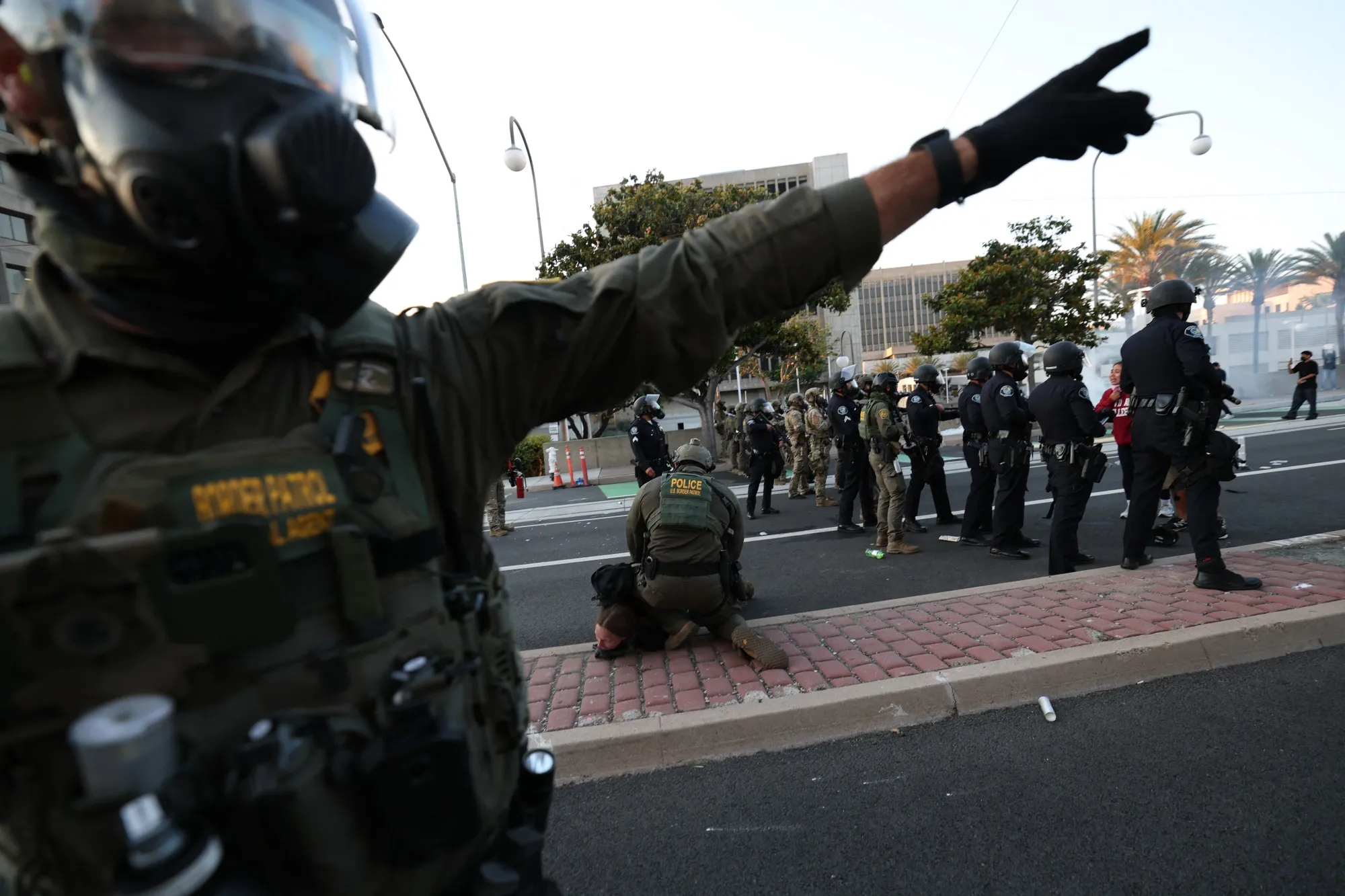A US Border Patrol agent gestures as another agent arrests a protester near the United States Citizenship and Immigration Services Santa Ana Field Office after protesters gathered following reports of ICE raids in Santa Ana, California, on June 9.